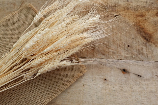 Foto trigo seco y saco de tela en el tablero de madera