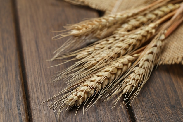 Foto trigo en tela de arpillera en mesa de madera