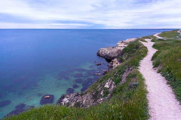 Trilha de montanha na encosta com fundo do mar