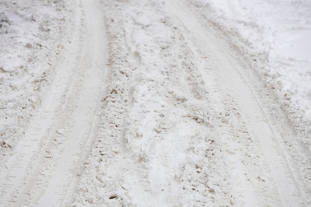 Foto trilha de pneus de carro na neve. estrada de inverno não coletada. foto de alta qualidade