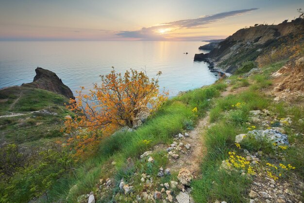 Foto trilha nas montanhas acima do mar ao pôr do sol