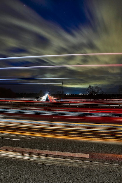 Trilhas de luz na estrada contra o céu à noite