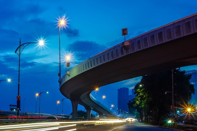 Trilhas de luz na estrada contra o céu azul à noite