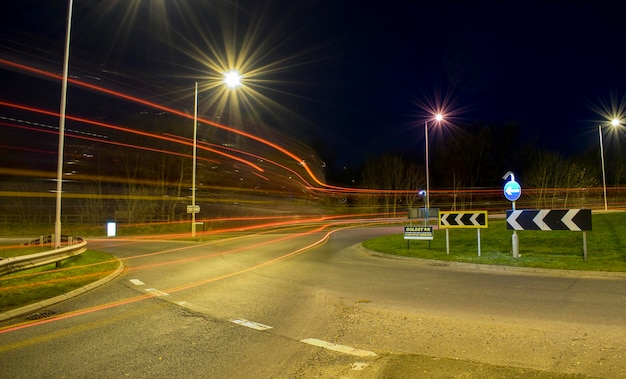 Foto trilhas de luz sobre a estrada por luzes de rua à noite