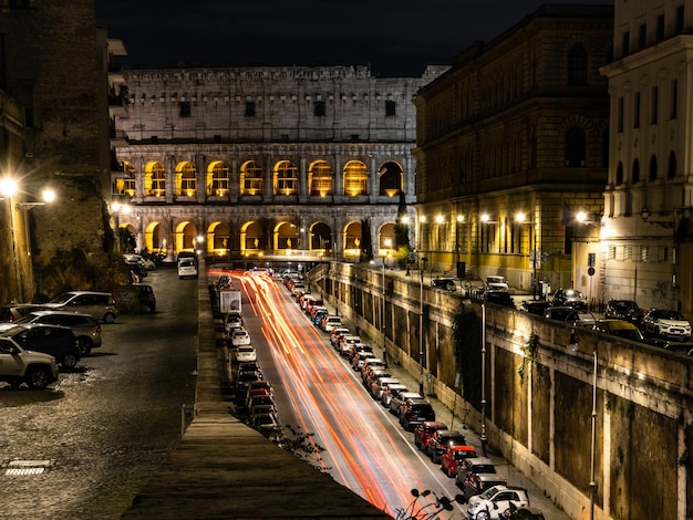 Trilhas leves de carros perto do Coliseu à noite ou à noite Roma Italy Famous World Landmark