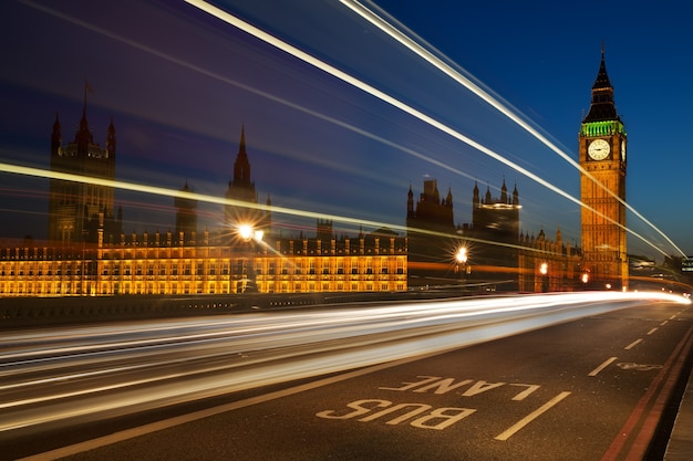 Trilhas leves de veículos com casas de westminster à distância