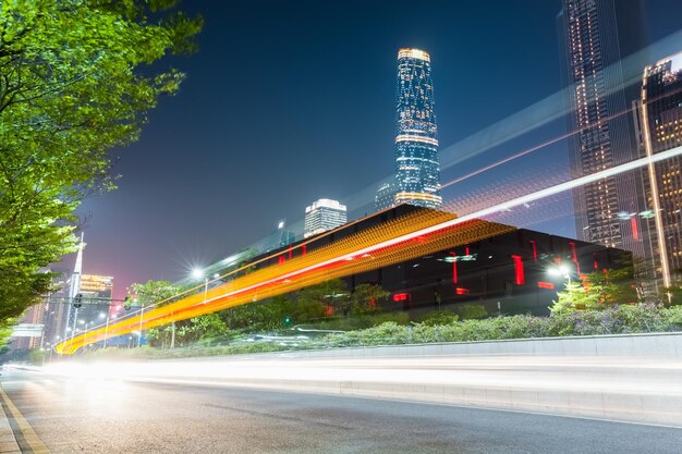 Trilhas leves na estrada da cidade com cidade futurista no distrito empresarial central de guangzhouxA