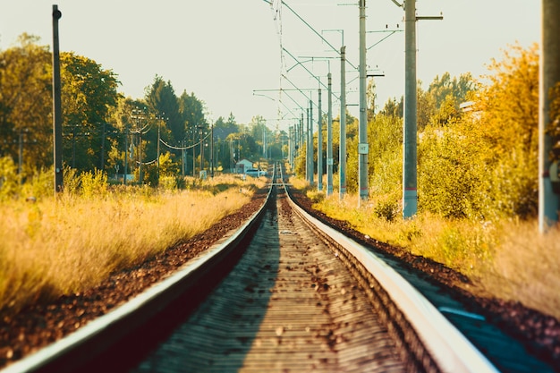 Trilhos da ferrovia russa ao pôr do sol. Estrada de ferro. Trilhos