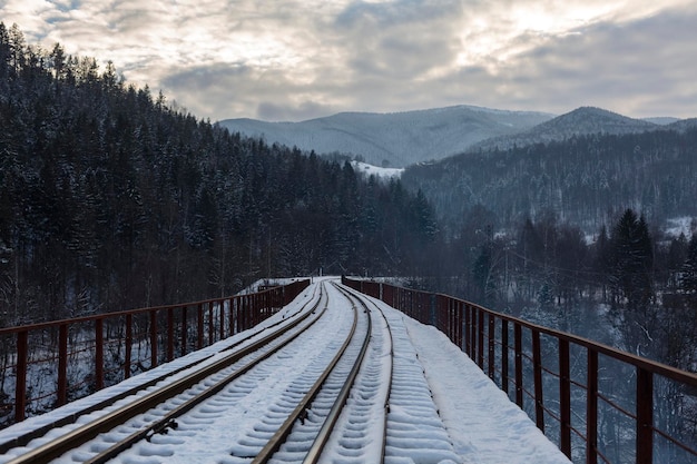 Trilhos em uma ponte ferroviária em montanhas nevadas