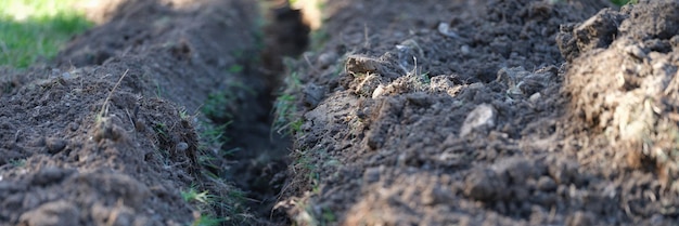 Trincheira escavada no gramado para colocar o conceito de paisagismo fechado do sistema de irrigação