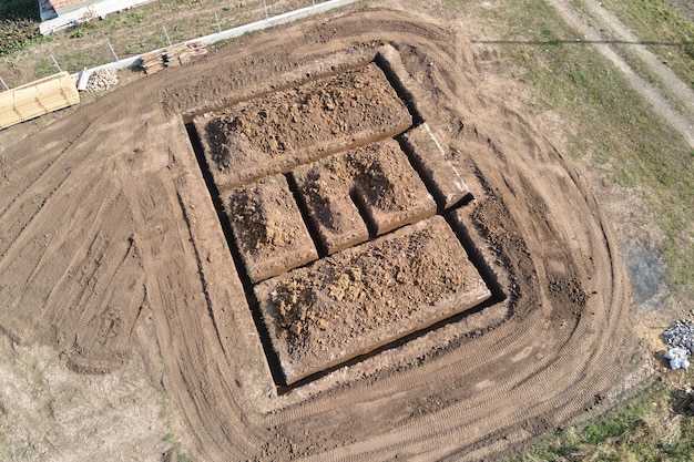 Trinchera excavada para obras de construcción de cimientos de hormigón de nueva casa en el sitio de construcción