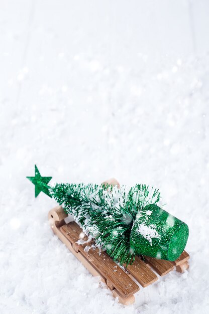 Trineo de madera de invierno con un pequeño árbol de navidad