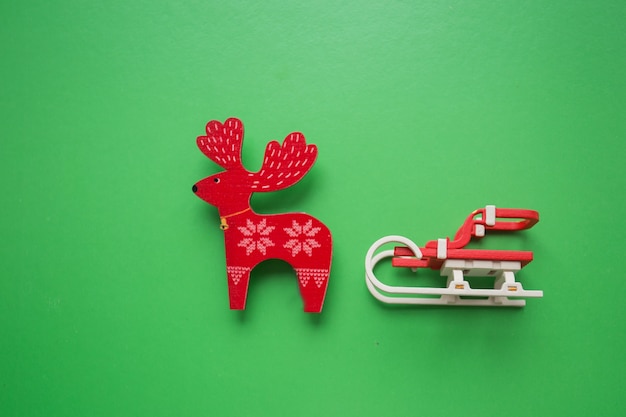 Trineo de Navidad con ciervos sobre fondo verde. juguete.