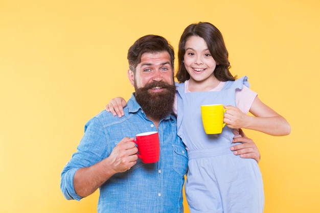 Trinken Sie mehr Milch Kleine Tochter und Vater halten Becher Milch Glückliche Familie trinkt Milchtee Molkereiprodukt Gesunde Ernährung Milch ist wichtig