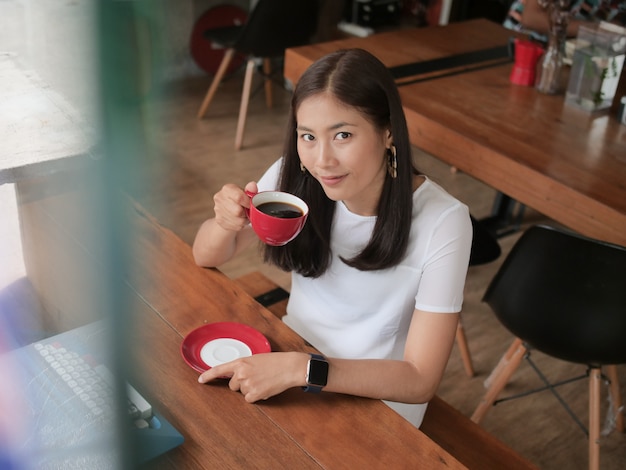 Trinkender Kaffee der Asiatin im Kaffeestube-Café