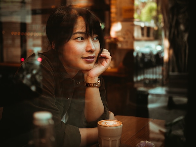 Trinkender Kaffee der Asiatin im Kaffeestube-Café