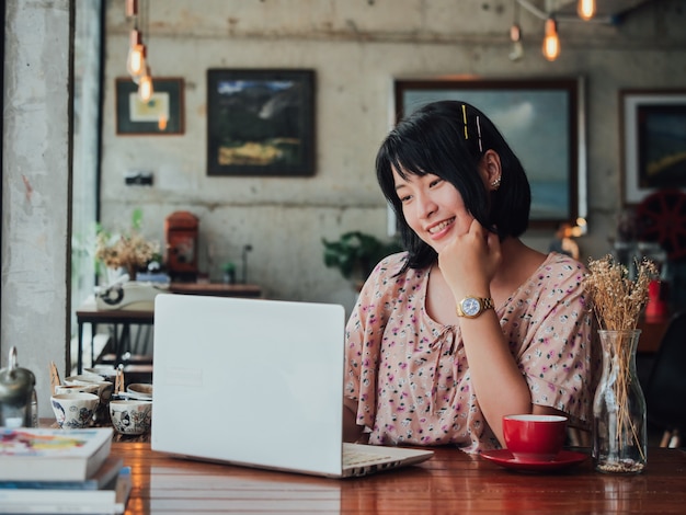 Trinkender Kaffee der Asiatin und entspannen sich im Kaffeeshopcafé