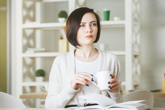 Trinkender Kaffee der attraktiven jungen Frau