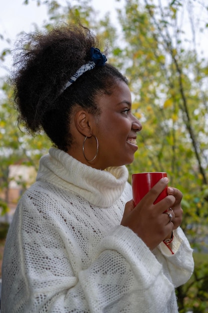 Trinkender Kaffee der glücklichen afroamerikanischen Frau