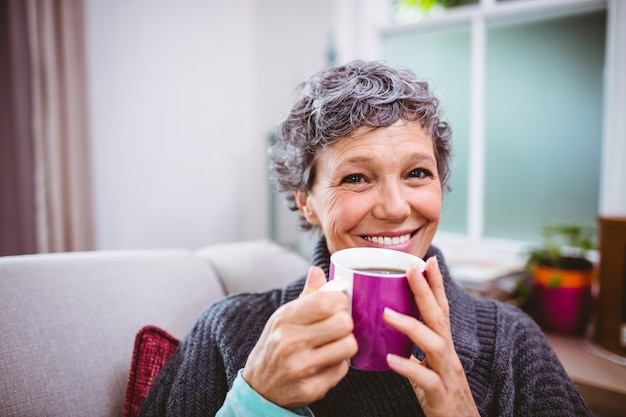 Trinkender Kaffee der glücklichen reifen Frau zu Hause