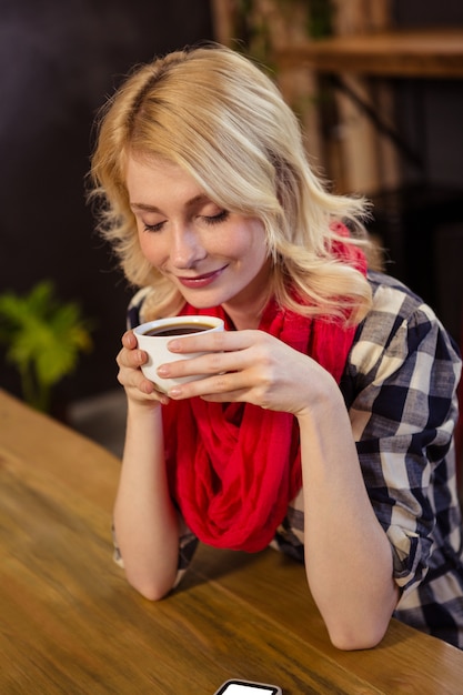 Trinkender Kaffee der jungen Frau in der Cafeteria