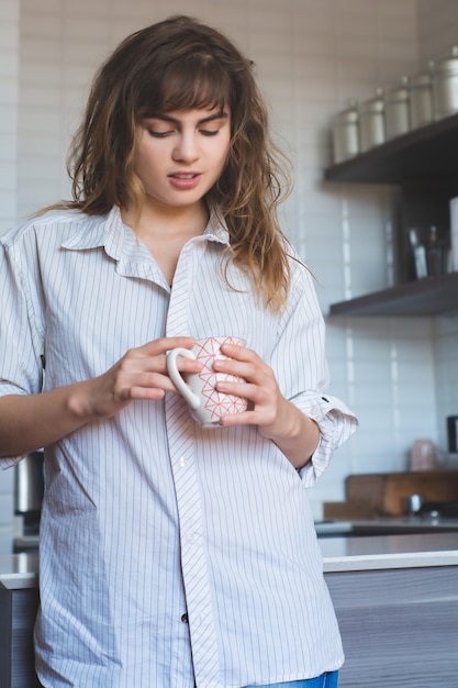 Trinkender Kaffee der jungen Frau zu Hause