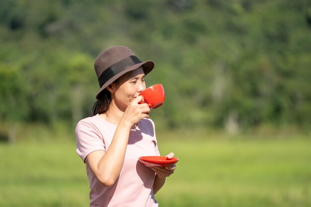 Trinkender Kaffee des Mädchens an im Freien der schönen Natur auf Hügeln