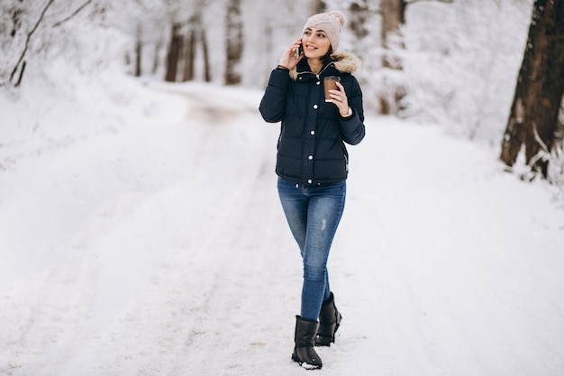 Trinkender Kaffee des Mädchens und draußen sprechen am Telefon im Winter