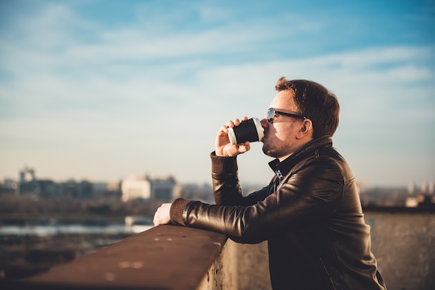 Trinkender Kaffee des Mannes auf der Dachspitze