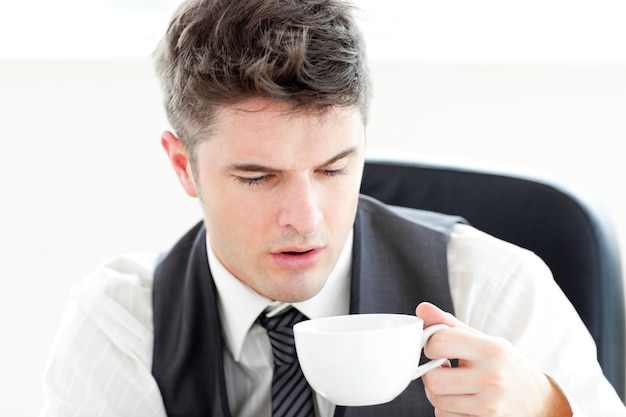 Foto trinkender kaffee des müden geschäftsmannes