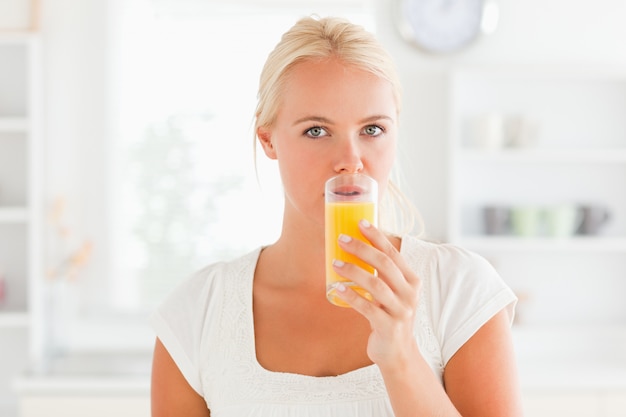 Trinkender Saft der blonden Frau