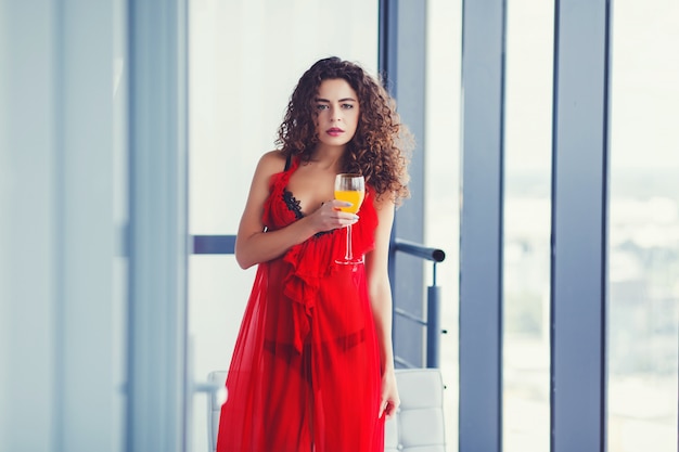 Trinkender Saft der gelockten Frau