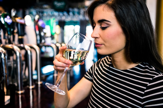 Trinkender Wein der attraktiven Frau in einer Bar