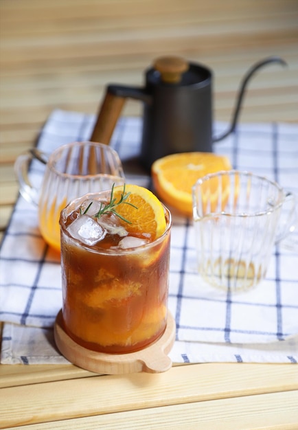Trinkendes Vorbereiten der Zubereitung von orangefarbenem Americano-Kaffee in der Freizeit von Menschen, die das Leben leben