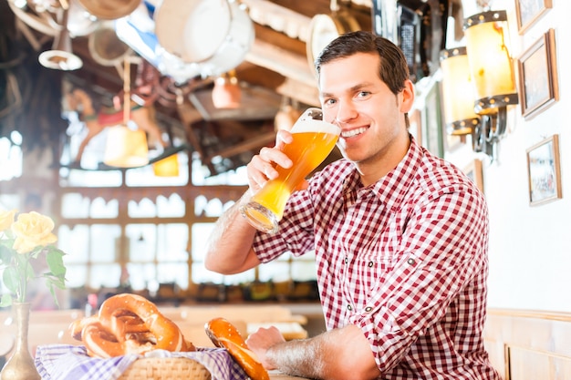 Trinkendes Weizenbier des bayerischen Mannes