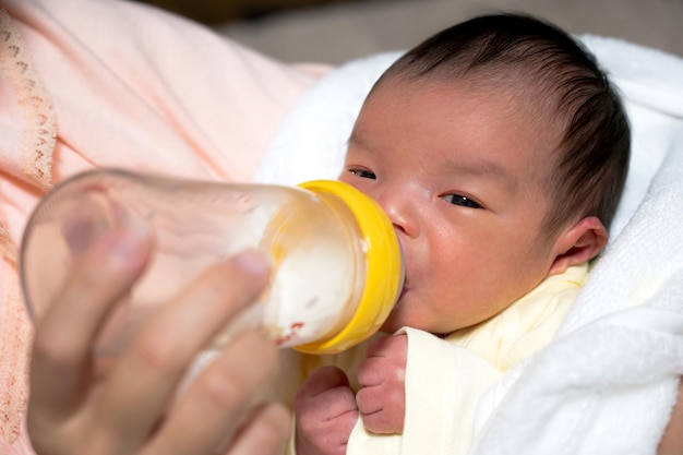 Trinkmilch des Babys in einer Babyflasche