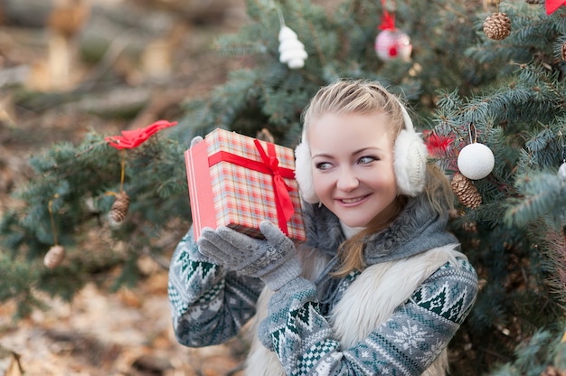 Trinkpunsch der jungen Frau auf Weihnachtsmarkt.