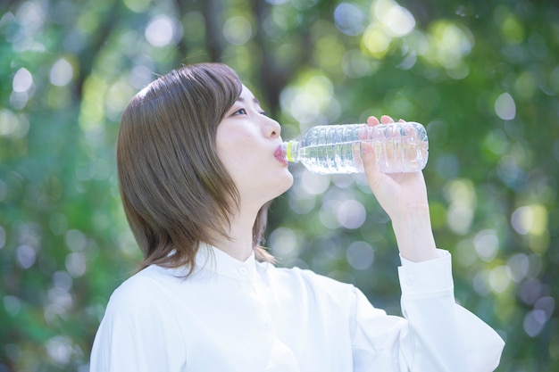 Trinkwasser der asiatischen jungen Frau