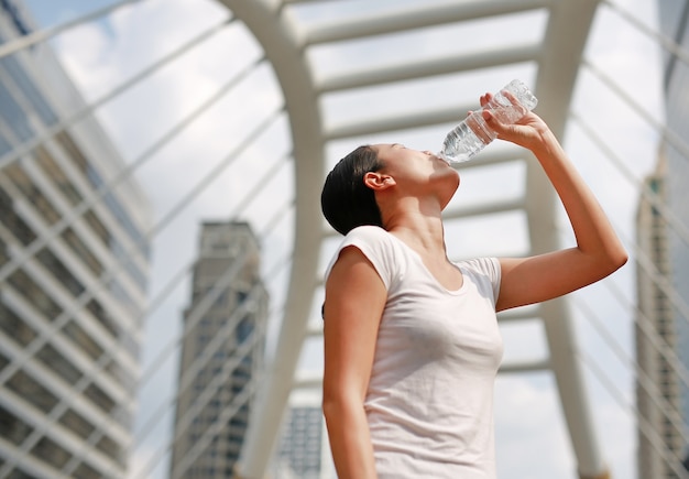 Trinkwasser der durstigen Frau öffentlich im Bereich.