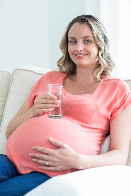 Trinkwasser der schwangeren Frau im Wohnzimmer