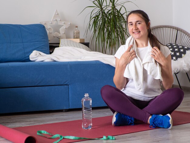 Trinkwasser des Mädchens nach Yoga zu Hause