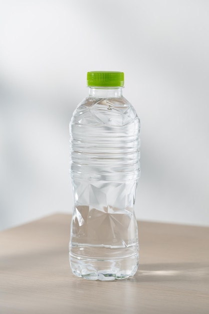 Trinkwasser in Plastikflaschen auf einem Holztisch unter dem Morgensonnenlicht