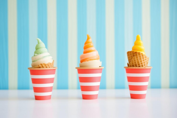 Trío de sorbetes en conos de gofre sobre fondo rayado