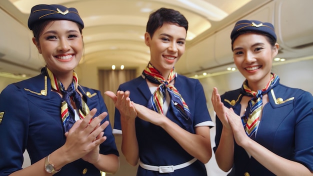 Tripulación de cabina aplaudiendo en avión. Concepto de transporte y turismo de aerolíneas.