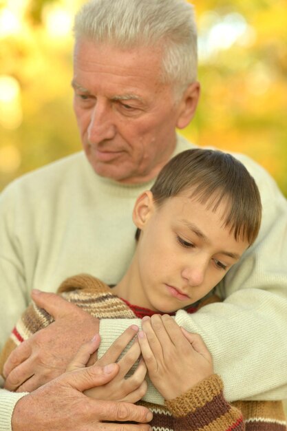 Triste abuelo y nieto abrazándose en el parque