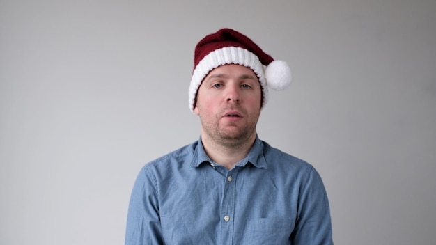 Foto el triste y afligido joven europeo con un sombrero de año nuevo mira sombríamente a la cámara decepcionando