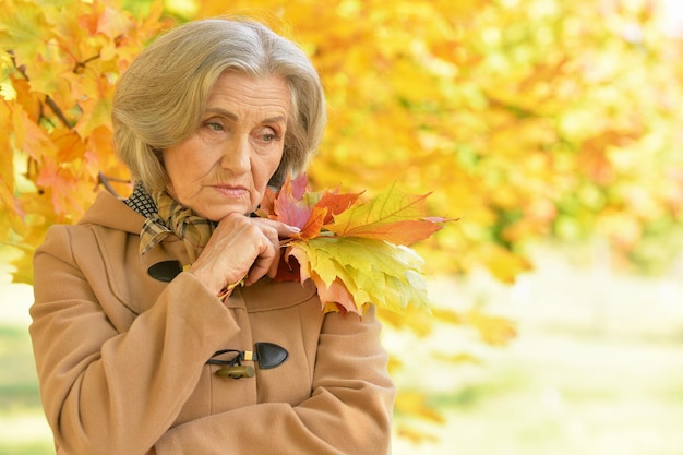 Triste anciana en el parque otoño