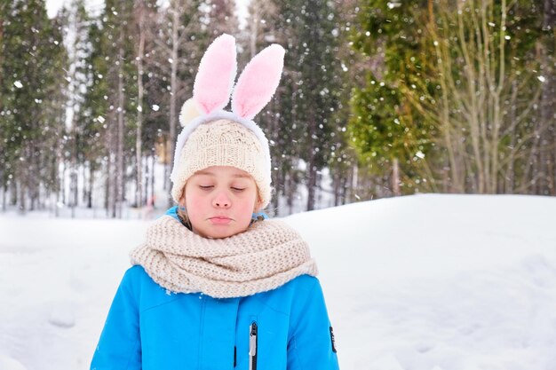 Triste chica adolescente al aire libre chica con orejas de conejo de carnaval en la cabeza triste por el clima nevado en primavera