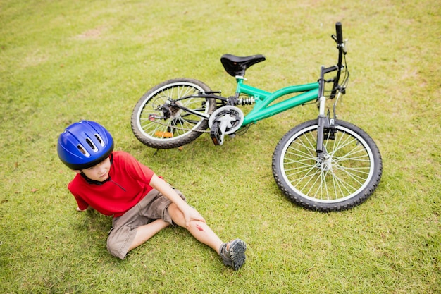 Triste criança caindo de sua bicicleta