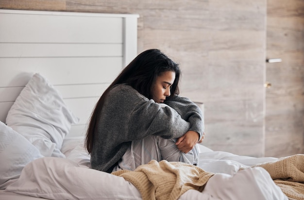 Triste depressão e mulher com estresse no quarto pensando em um coração partido ou problemas de saúde mental Divórcio menina estressada ou deprimida com insônia, ansiedade ou memória negativa em casa